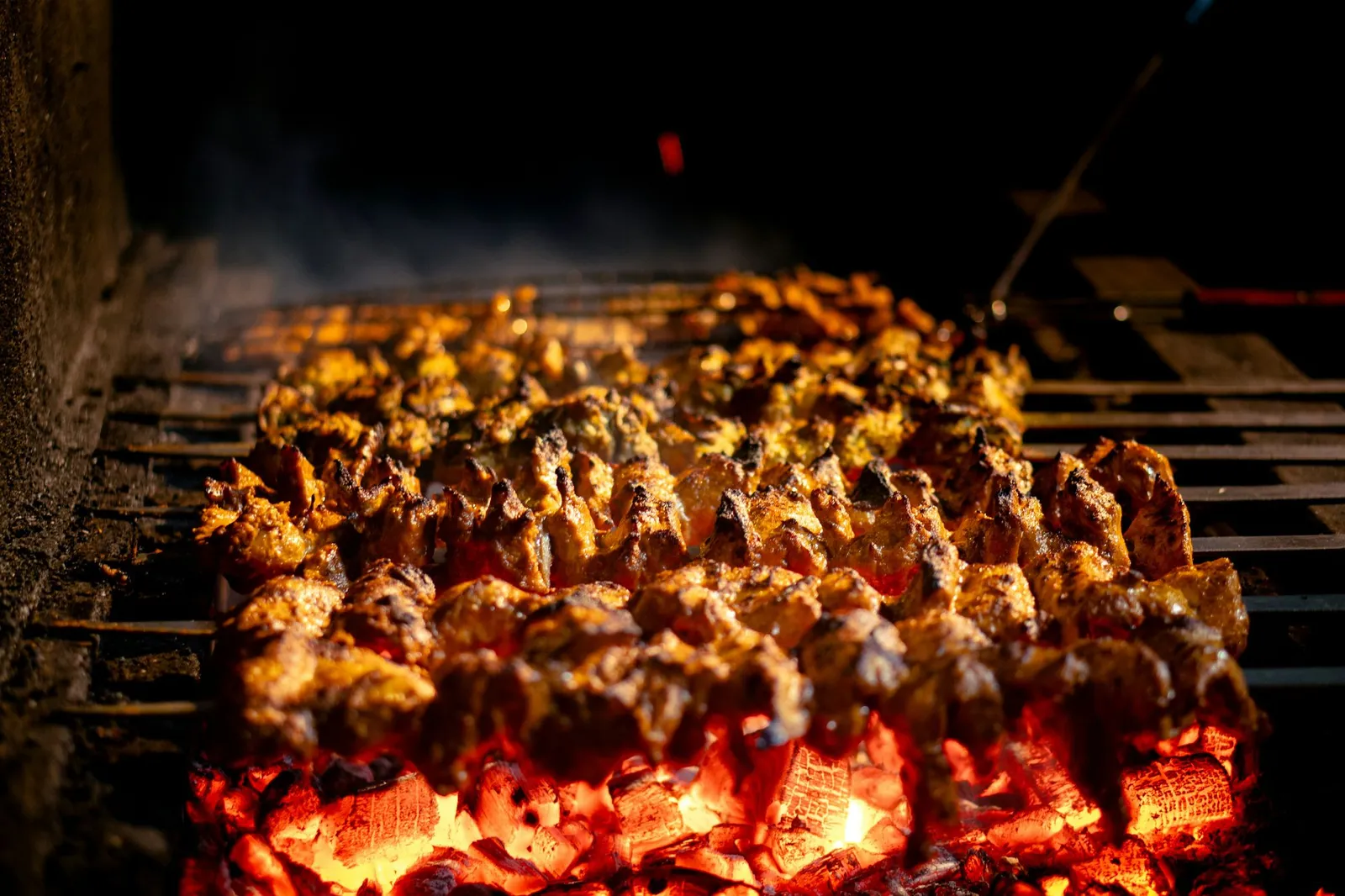 Brochettes qui grillent au-dessus des braises de charbon de bois